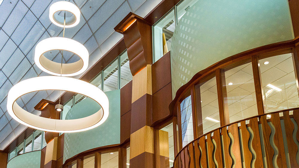 A circular light fixture hangs from the high ceiling in the law library