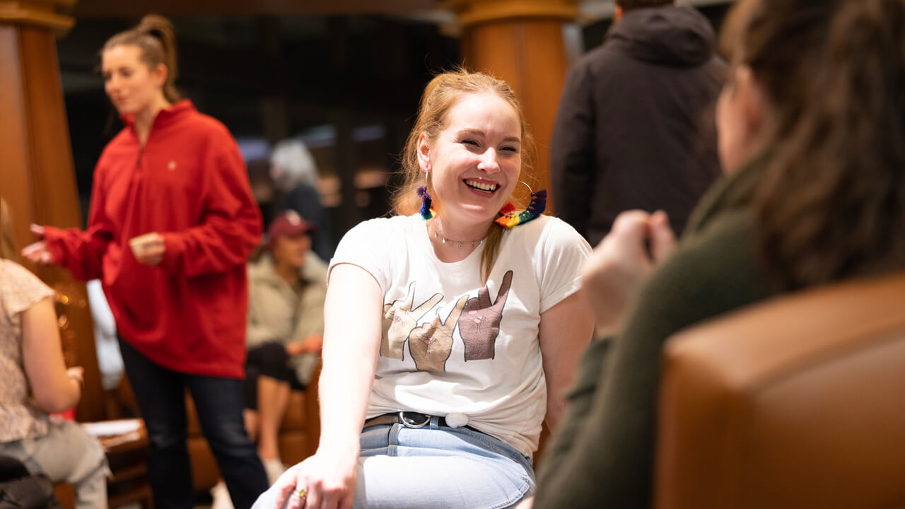 A female student smiling while talking to someone out of frame